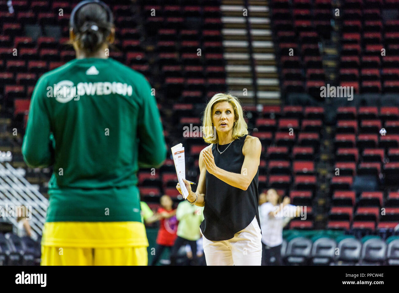 Testa femmina pullman a parlare con il giocatore prima del gioco del basket, Seattle, Washington, Stati Uniti d'America Foto Stock