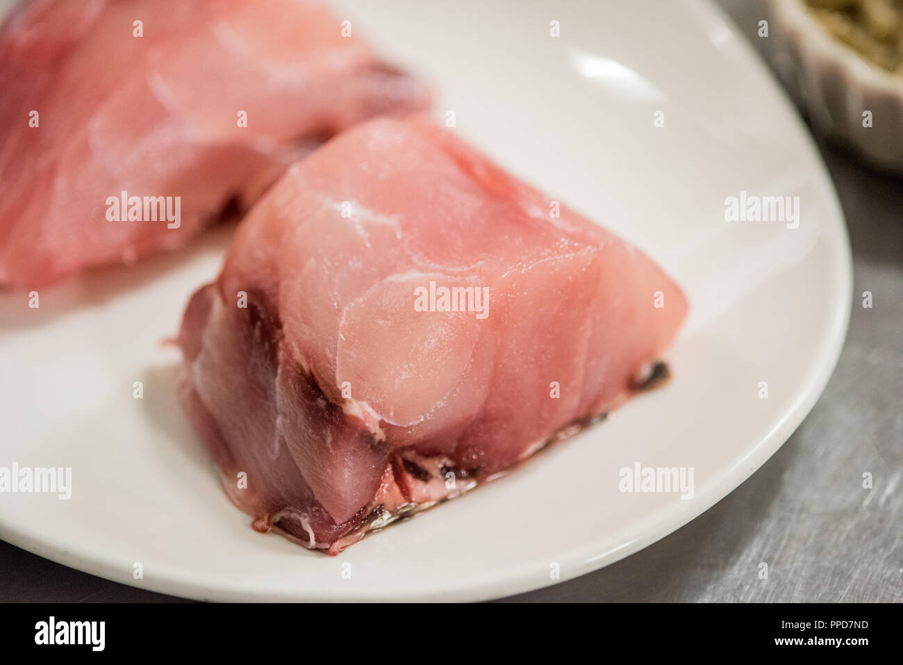 Un nuovo taglio di pesce si appoggia in preparazione per essere cotti in complemento di un granchio piatto imperiale. Foto Stock