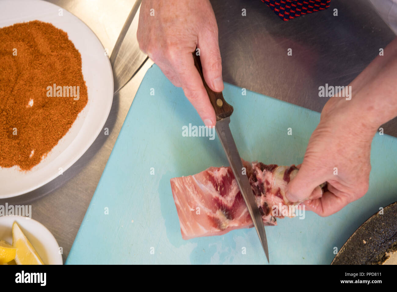 Un filetto di pesce viene tagliata e preparata per la cottura. Foto Stock
