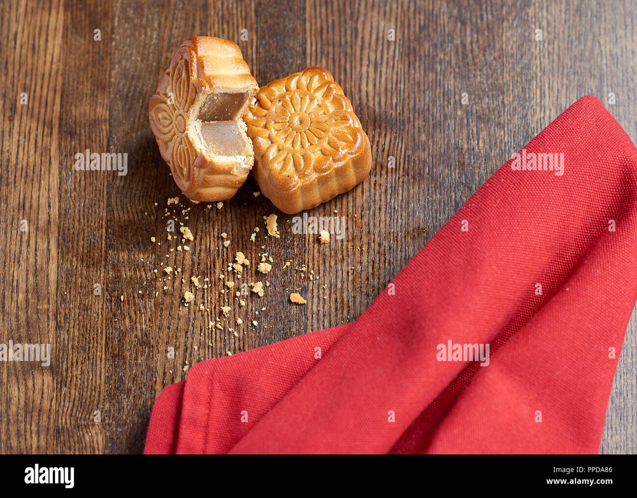 Mooncake tagliato su sfondo di legno con sfondo rosso Foto Stock