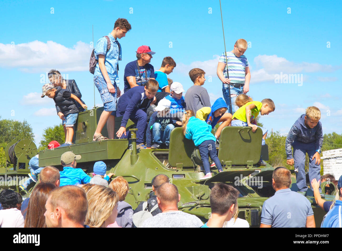 Ispezionare i bambini e giocare su un veicolo militare Foto Stock