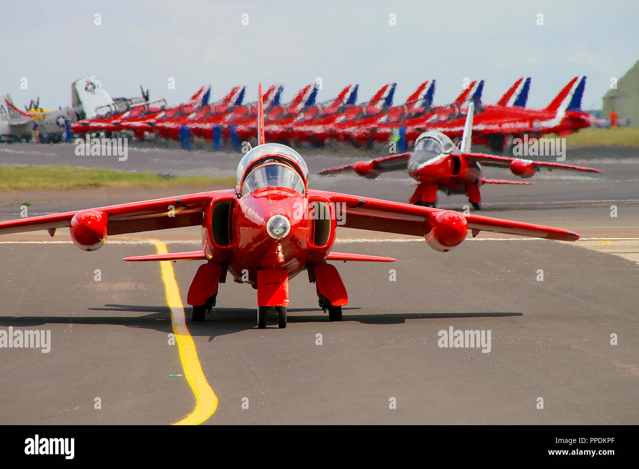 Rosso Display Gnat Team Folland Gnat T1 rullaggio fuori per un aria airshow display con la RAF Royal Air Force frecce rosse Hawk jet schierate al di là Foto Stock