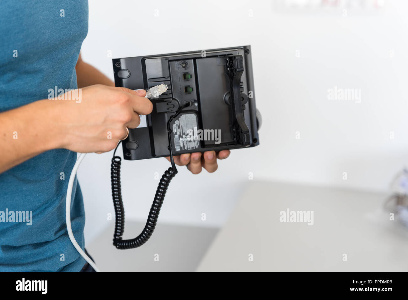 Specialista si collega il telefono alla rete di telefonia VoIP, tecnologia moderna Foto Stock