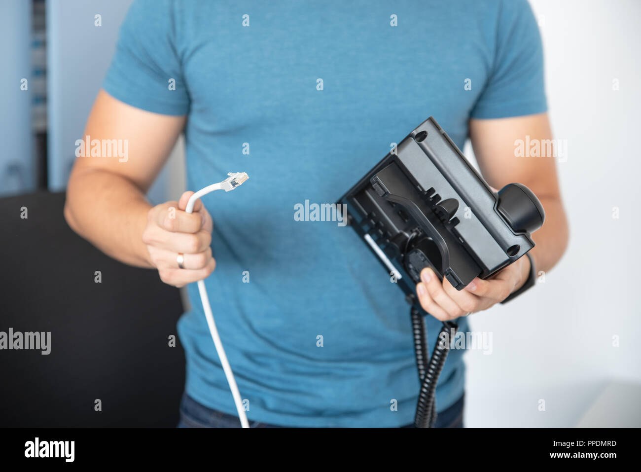 Specialista si collega il telefono alla rete di telefonia VoIP, tecnologia moderna Foto Stock