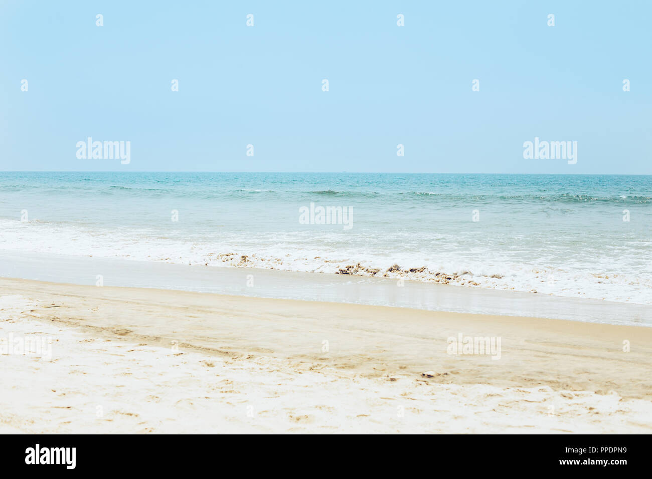 Spiaggia sabbiosa tropicale, il mare con le onde e il cielo sereno. Estate paradiso vista dell'oceano shore con un orizzonte blu. Arabian costa, Goa Sud, Ind Foto Stock