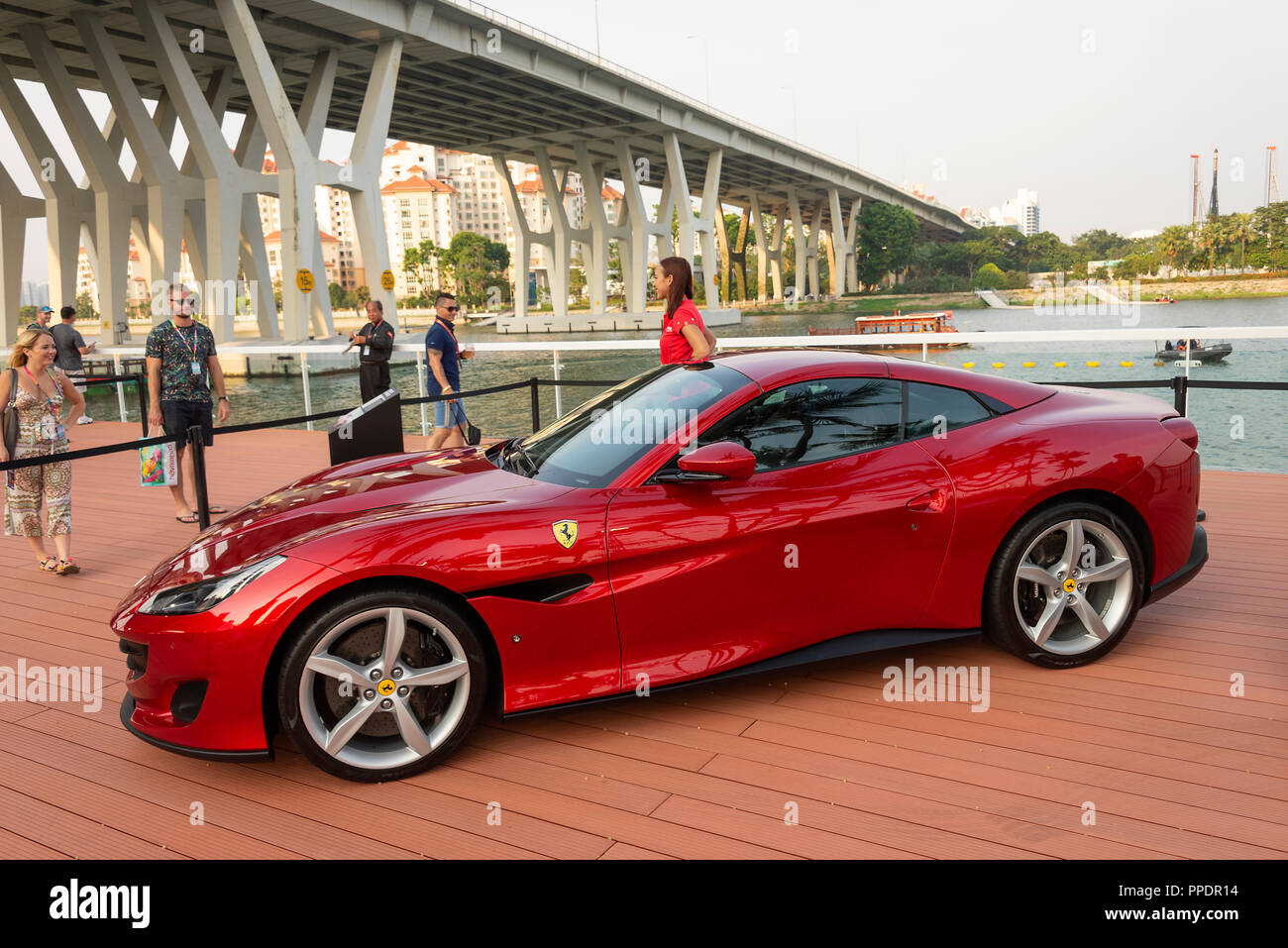 Ferrari Portofino Drop-Top lusso Auto sportiva sul display con un attraente modello al Gran Premio di F1 di Marina Bay Singapore Asia Foto Stock