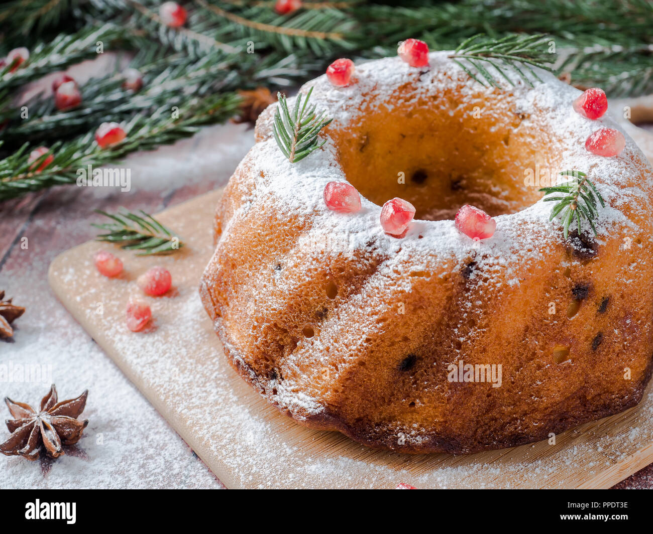 Torta di Natale in forma di una corona di fiori con decorazioni di Natale. Melograno stella di anice Abete rami Foto Stock