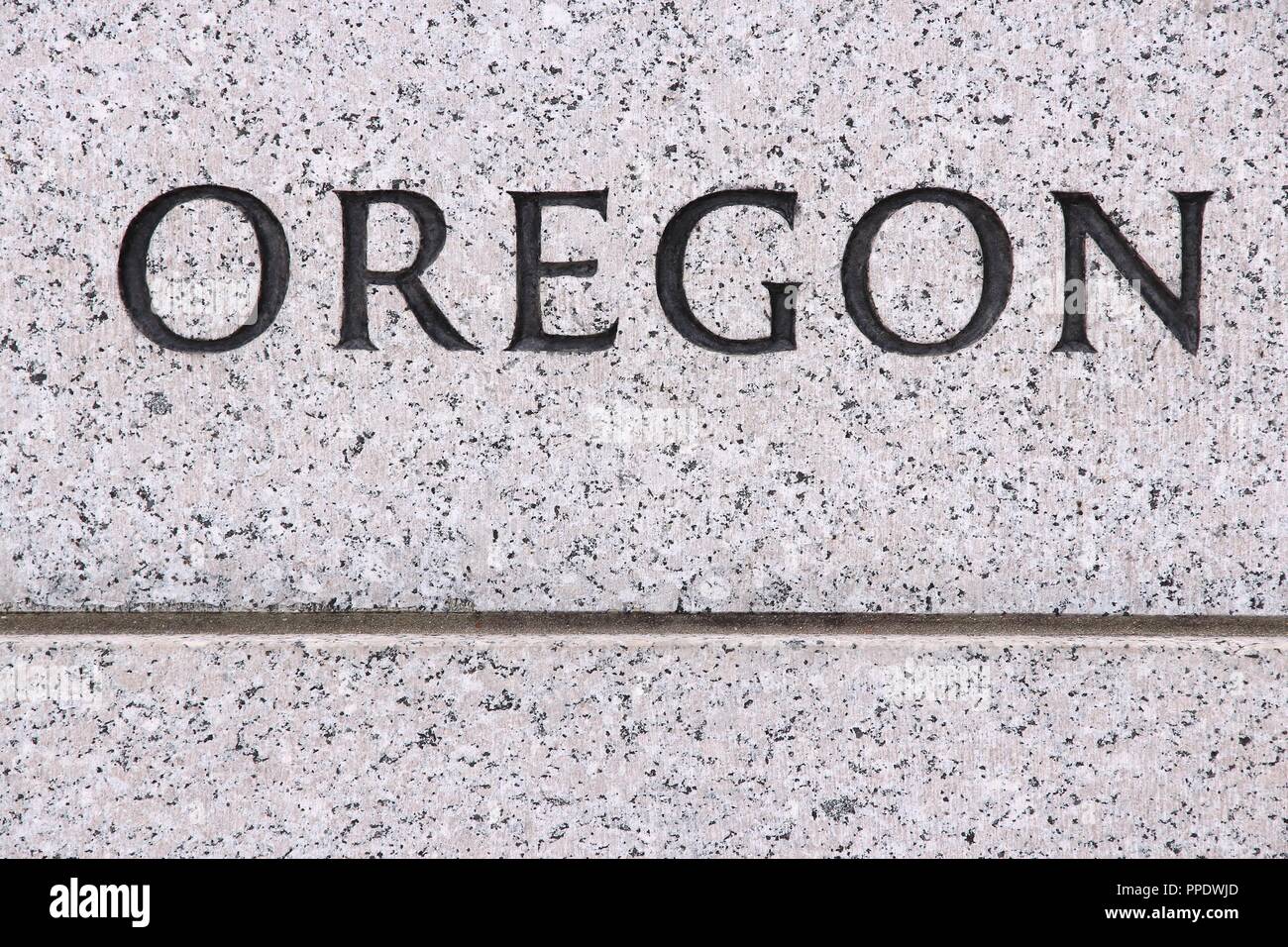 Oregon - USA nome stato scolpito in grigia pietra di granito Foto Stock