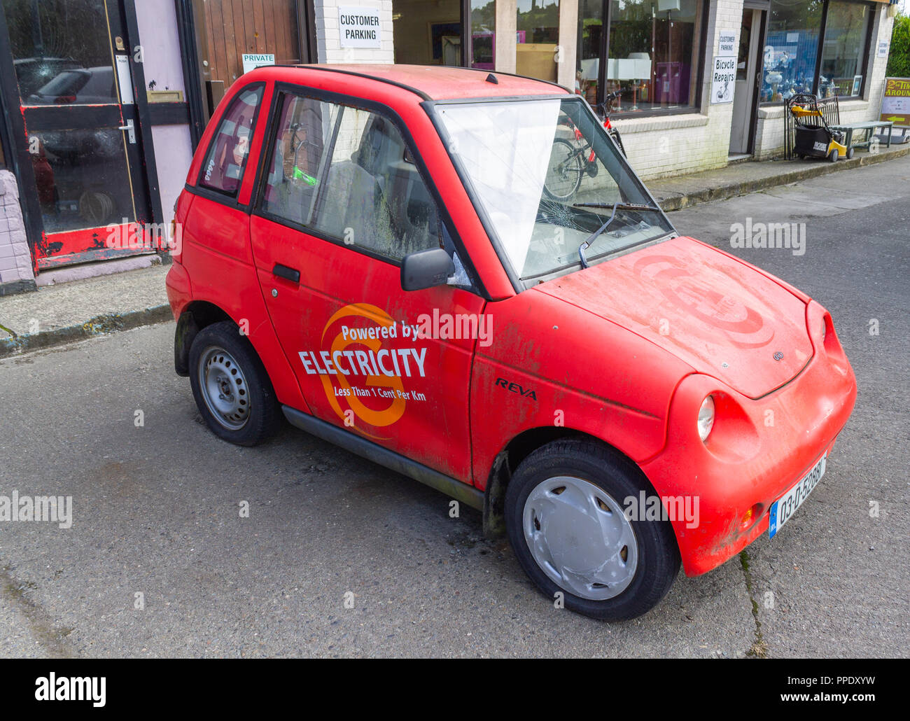 Reva electric car dipinte di rosso alimentato da energia elettrica Foto Stock