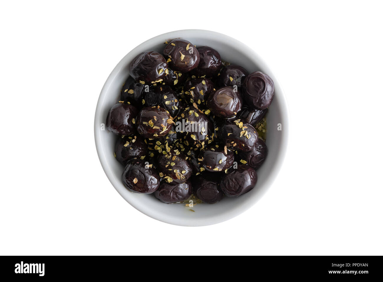 Ciotola di deliziosi piatti conditi con grado A Mediterraneo black olive aromatizzati con erbe fresche servita in una piccola ramekin bianco isolato su bianco Foto Stock