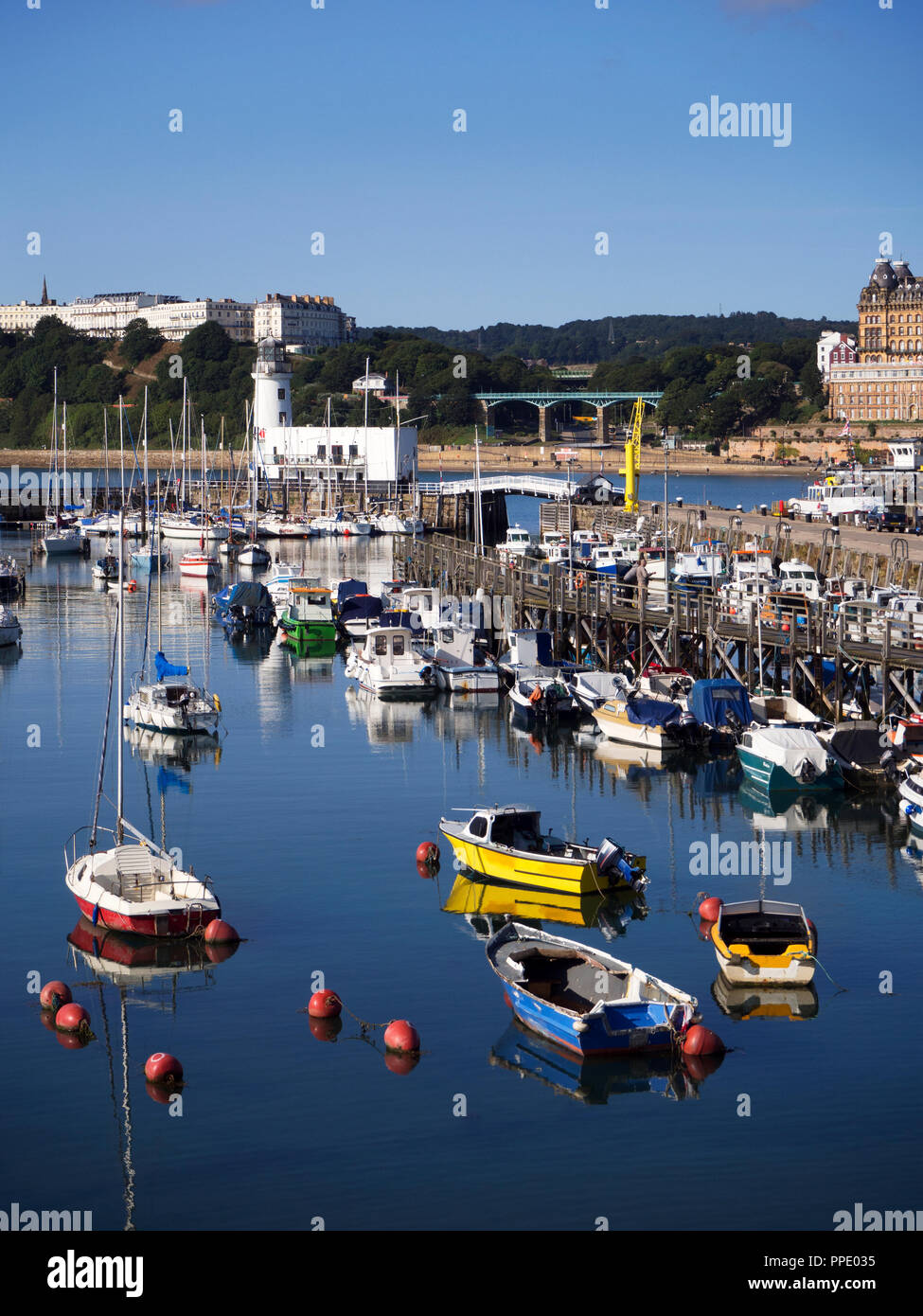 Le barche nel porto e il faro da est del molo a Scarborough North Yorkshire, Inghilterra Foto Stock