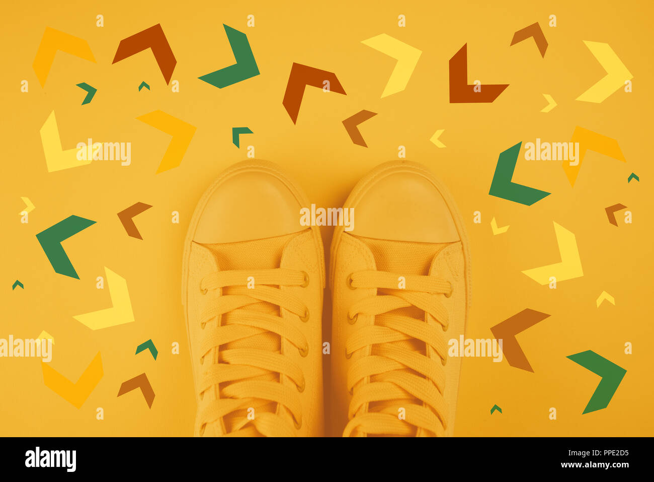 Prendere decisioni e scelte giuste nel concetto di vita, uno stile giovanile sneakers da sopra con le frecce rivolte verso direzioni diverse come se la persona ha avuto vari Foto Stock