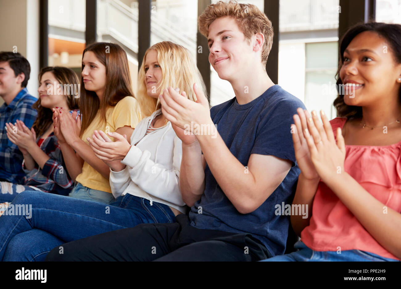 Un gruppo di studenti di scuola superiore ad applaudire la presentazione Foto Stock