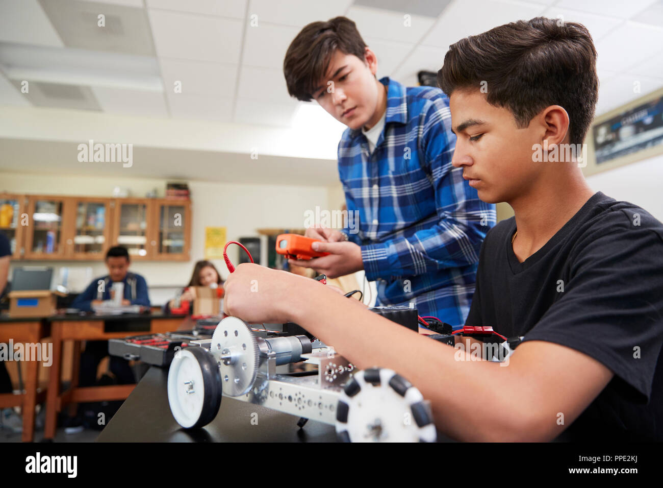 Due alunni maschi edificio veicolo robotico nella lezione di scienze Foto Stock