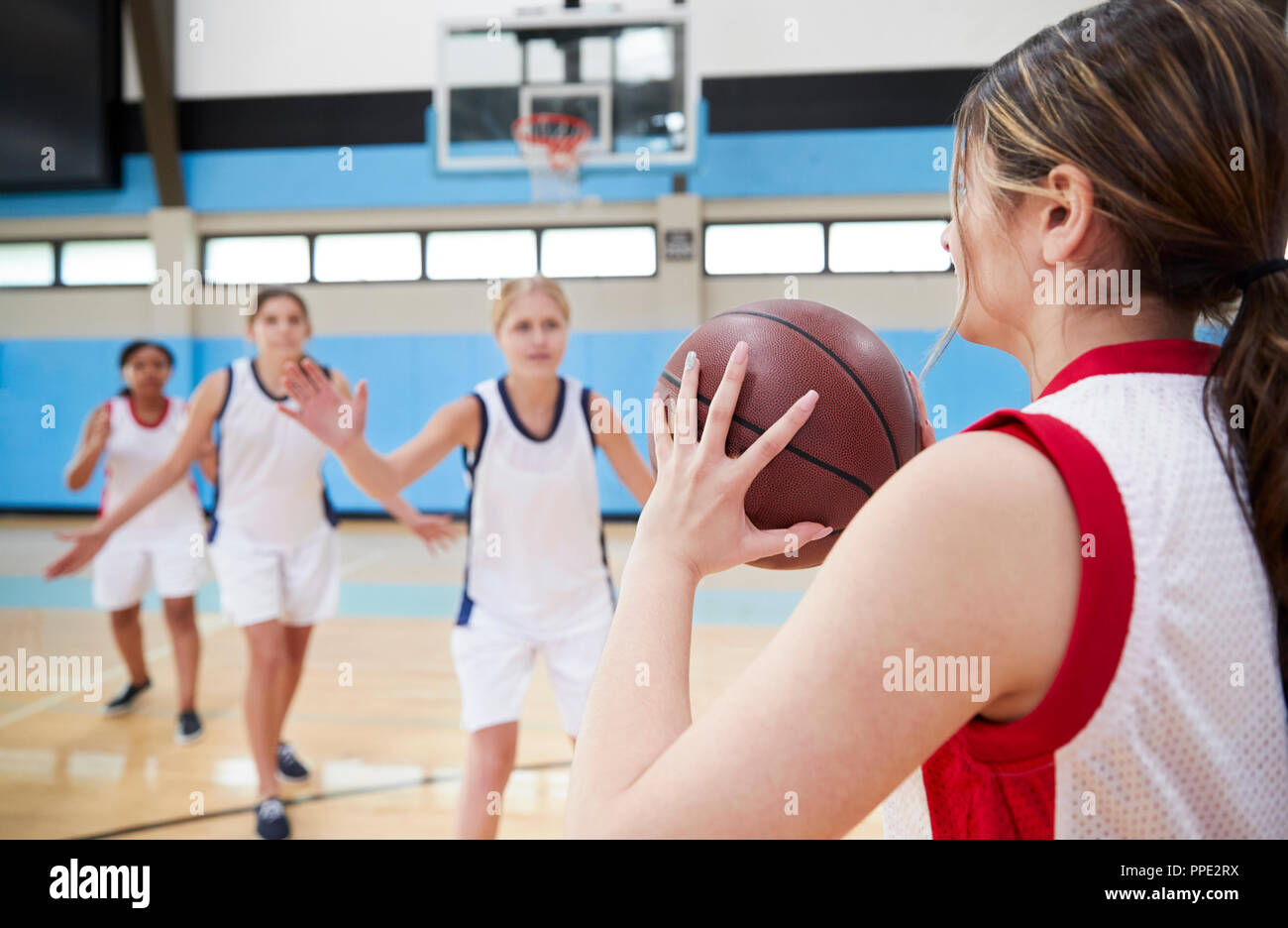 Femmina di alta scuola squadra di basket passando palla su corte Foto Stock