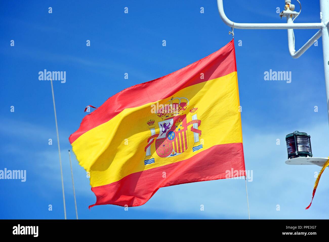 Bandiera spagnola su una barca da pesca contro un cielo blu, Ayamonte, Huelva, Andalusia, Spagna, Europa. Foto Stock