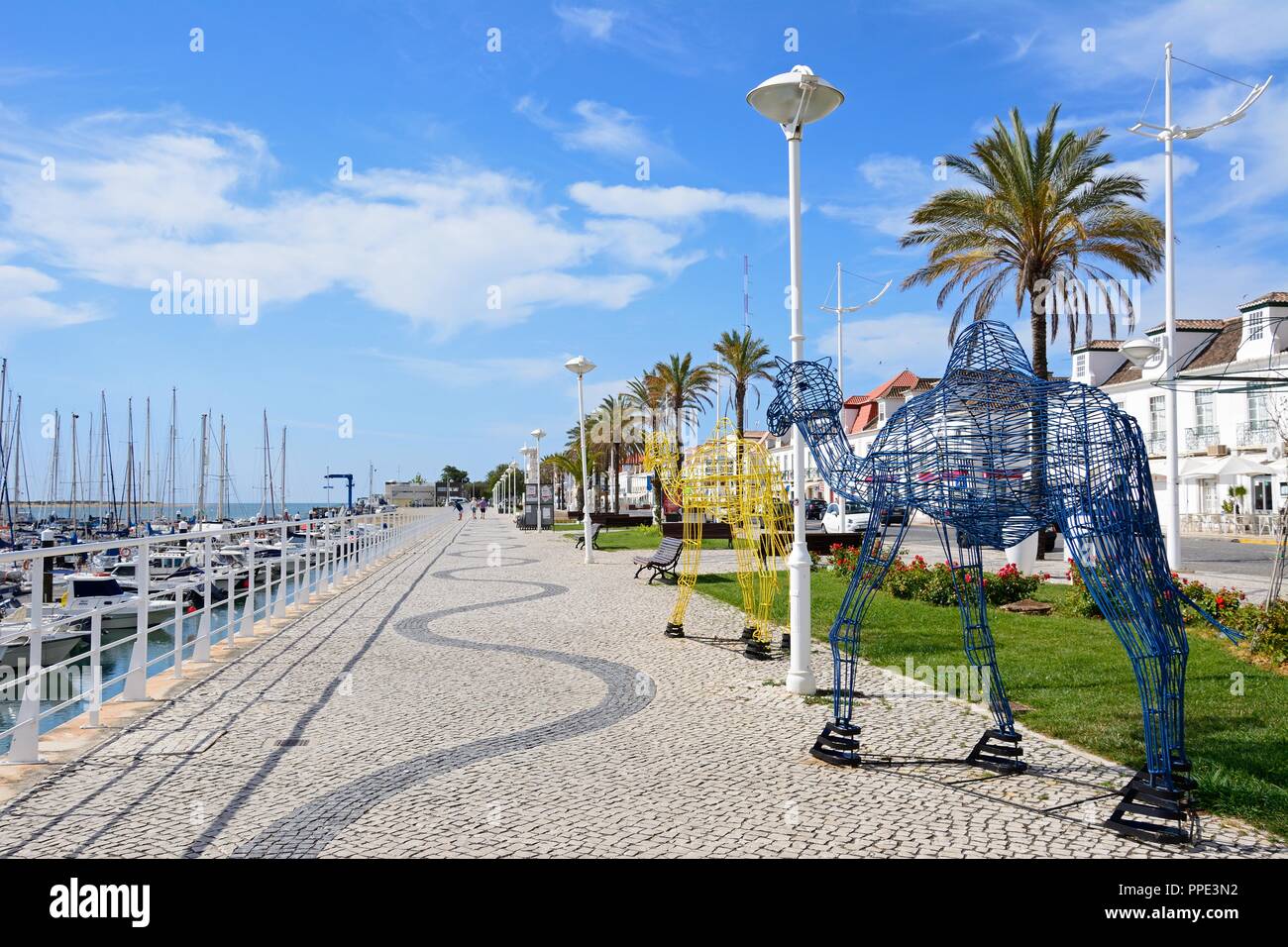 Telaio in metallo cammelli lungo la Av da Republica con yacht e barche ormeggiate in porto per il lato destro, Vila Real de Santo Antonio, Algarve, P Foto Stock