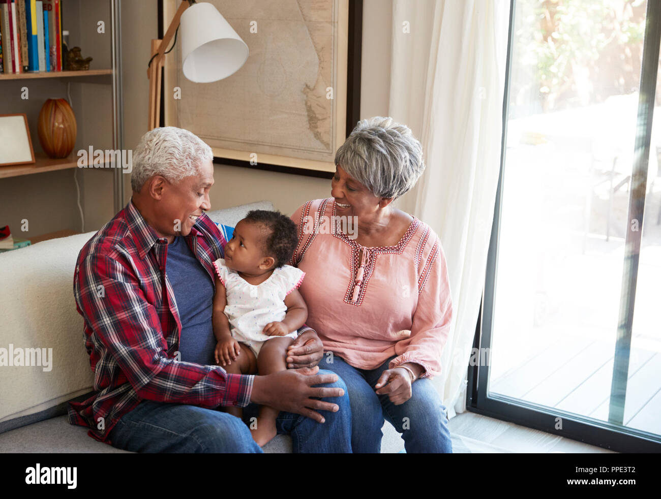 Nonni seduto sul divano con il bambino nipote a casa Foto Stock