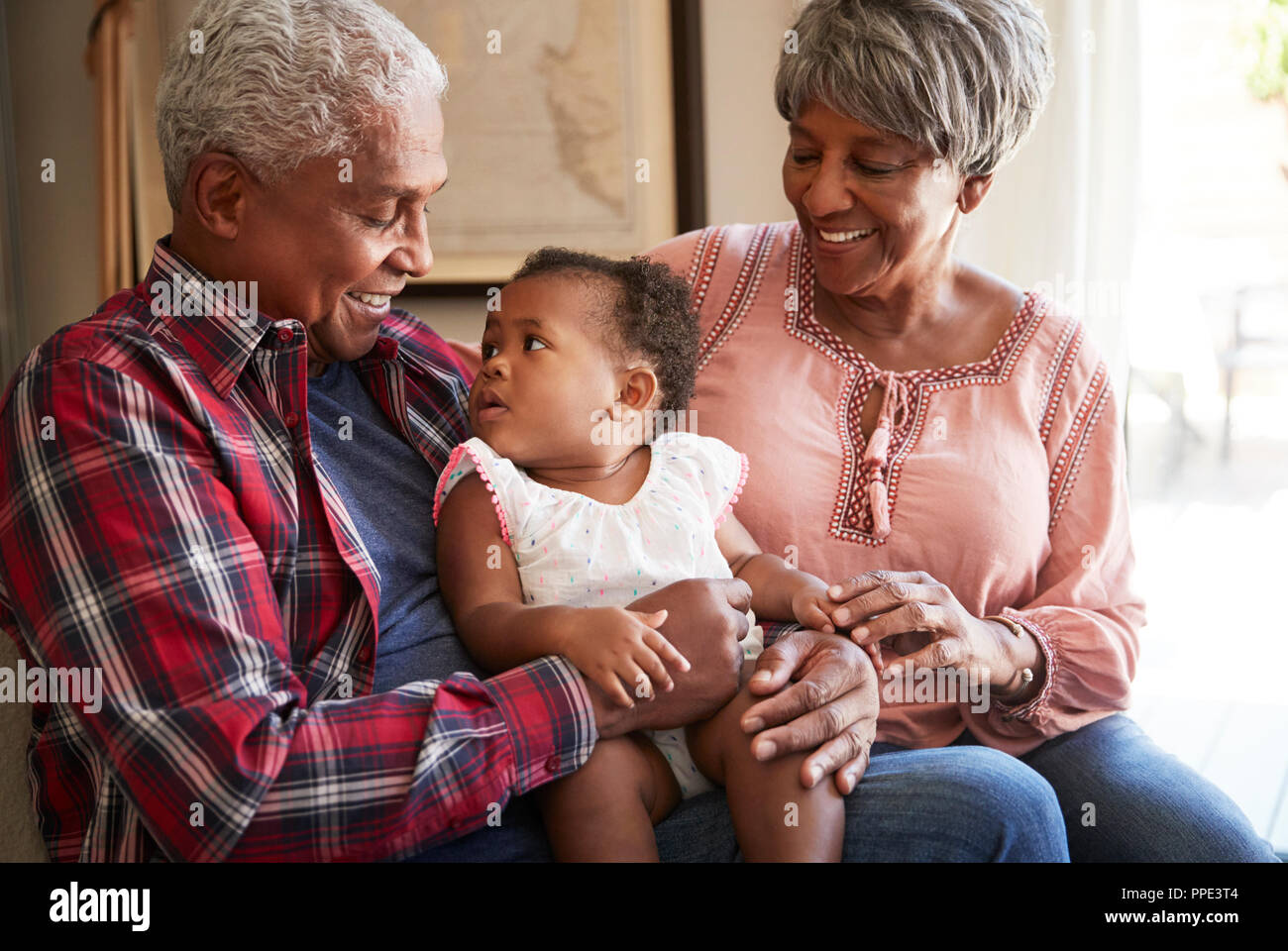 Nonni seduto sul divano con il bambino nipote a casa Foto Stock