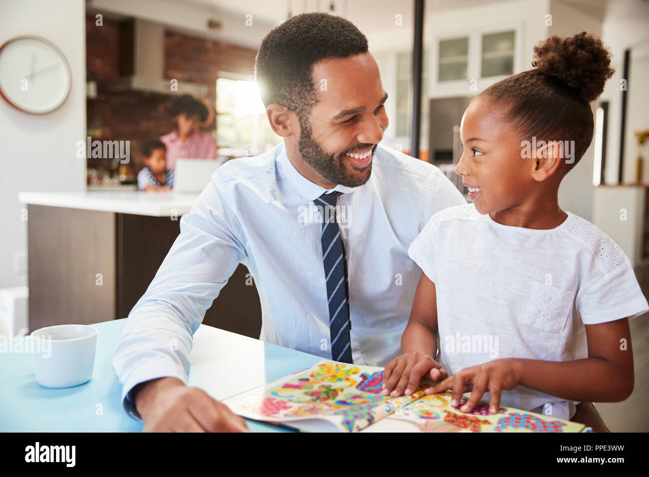 Padre Libro di lettura con la figlia prima di andare al lavoro Foto Stock