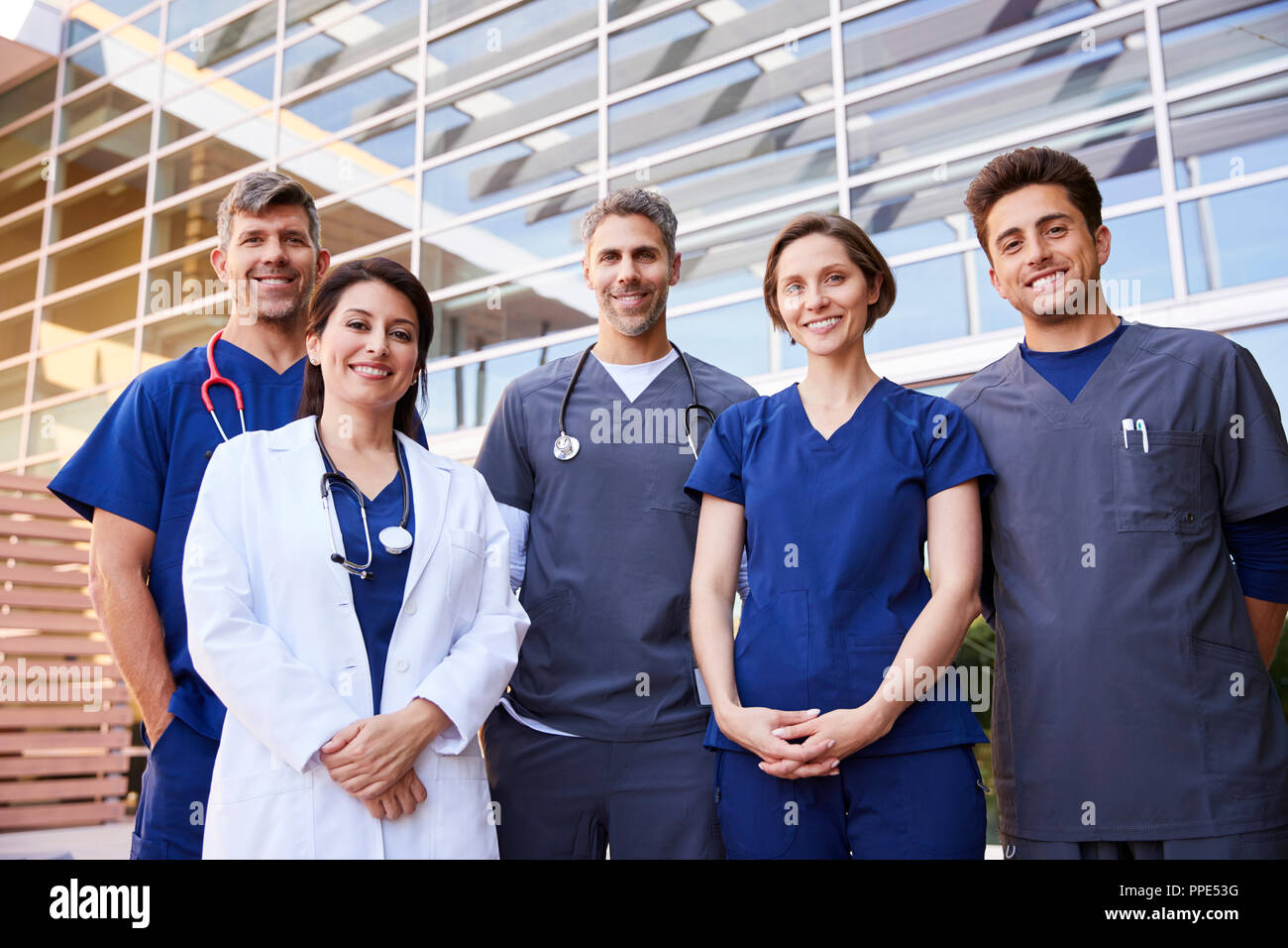 Cinque colleghi del settore sanitario in piedi all'aperto, ritratto di gruppo Foto Stock