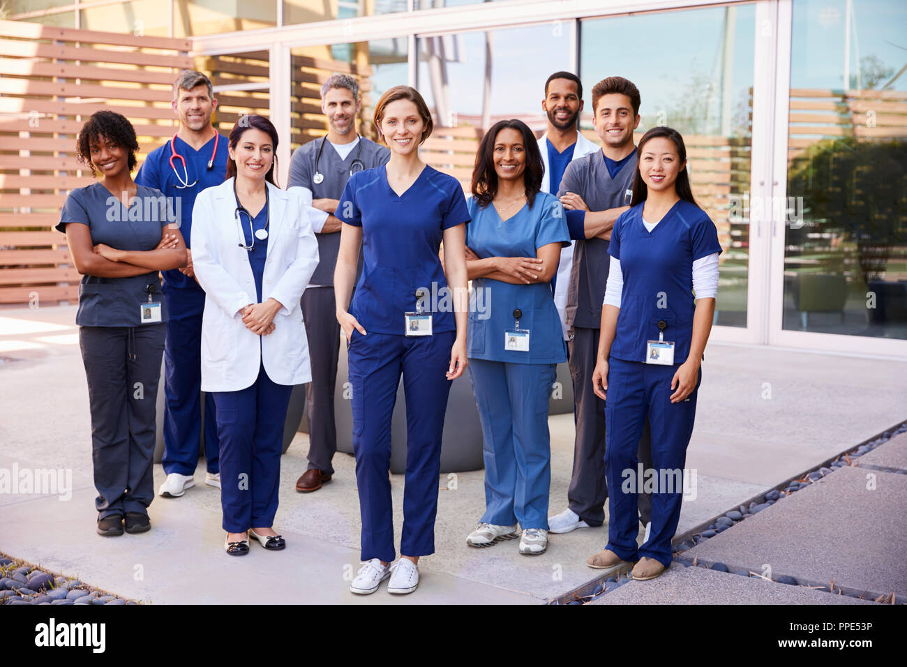 Il team sanitario con ID BADGE stand all'aperto, a piena lunghezza Foto Stock