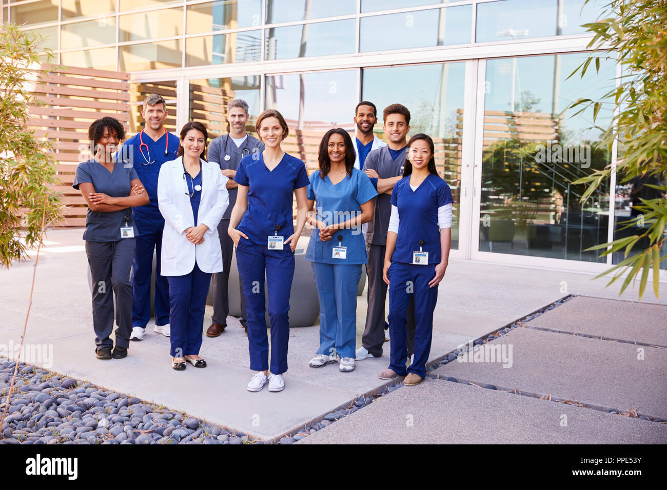 Il team sanitario con ID BADGE stand all'aperto, a piena lunghezza Foto Stock