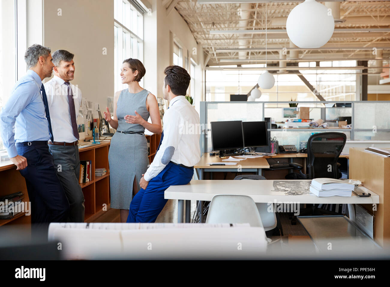 Donna manager in discussione con i colleghi al lavoro Foto Stock