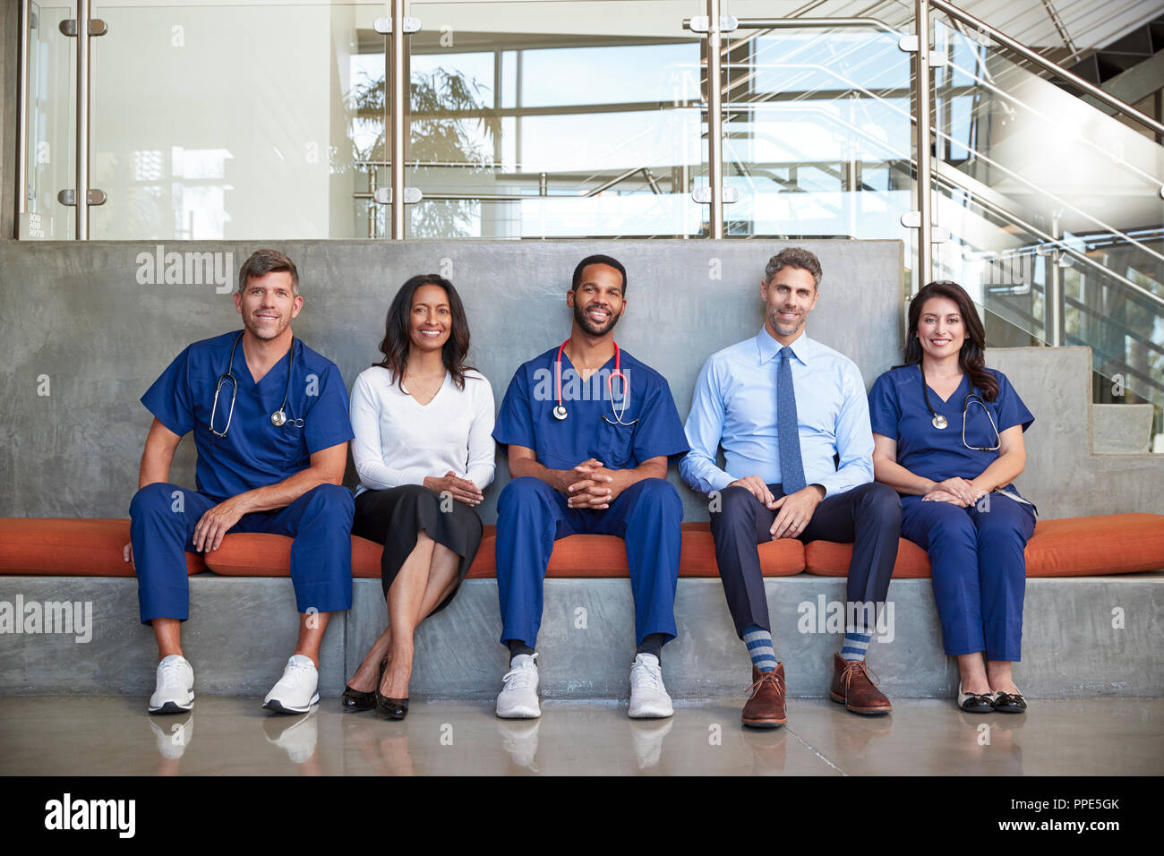 Cinque i lavoratori del settore sanitario seduta in ospedale a piena lunghezza Foto Stock