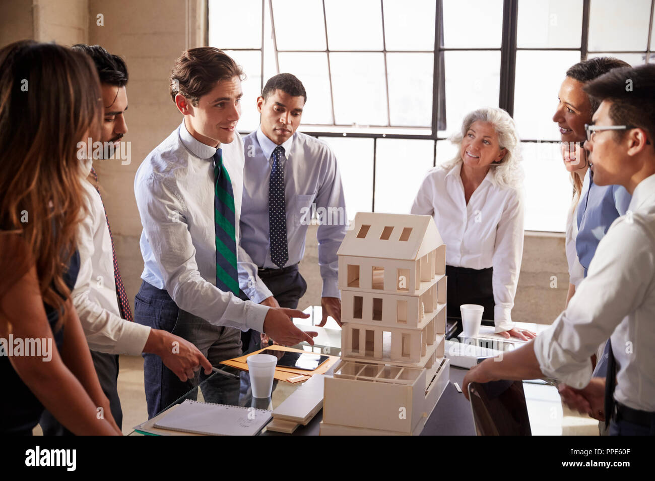 Architetti a discutere il modello in scala di un edificio Foto Stock