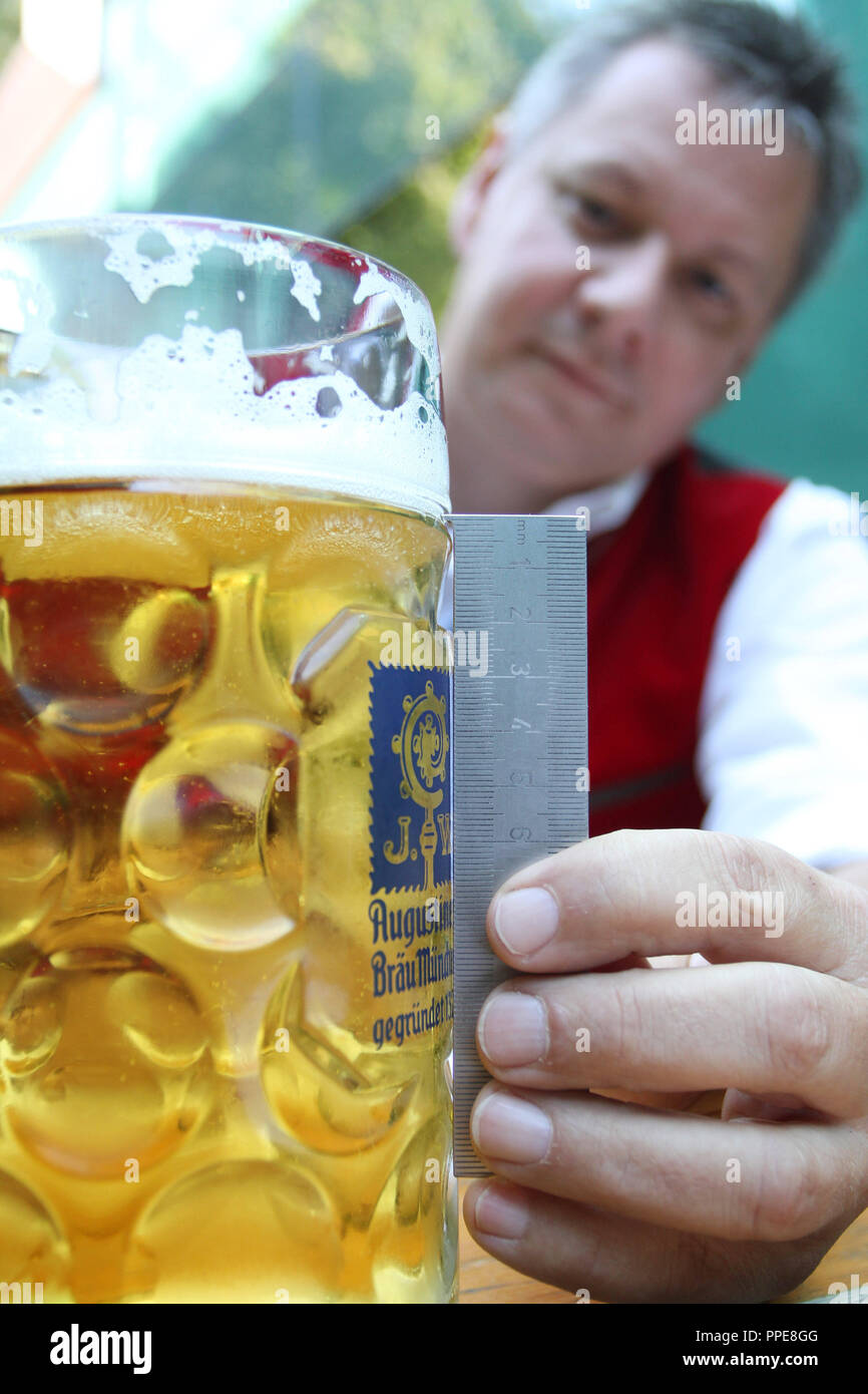 Dieter Felber, responsabile del controllo degli alimenti dipartimento presso il Monaco di Baviera Amministrazione distrettuale competente, mostra una perfettamente versata Wiesn birra in una tenda festival al Oktoberfest. Foto Stock