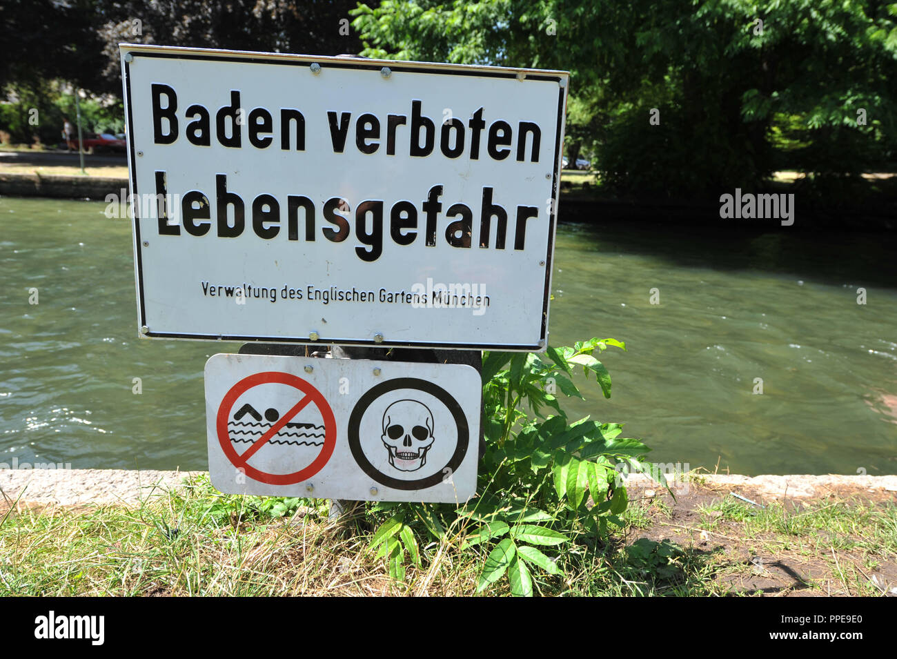 Un cartello con la scritta "la balneazione è vietata - pericolo per la vita' avverte nuotatori prima di un tuffo nel fiume Eisbach. Foto Stock