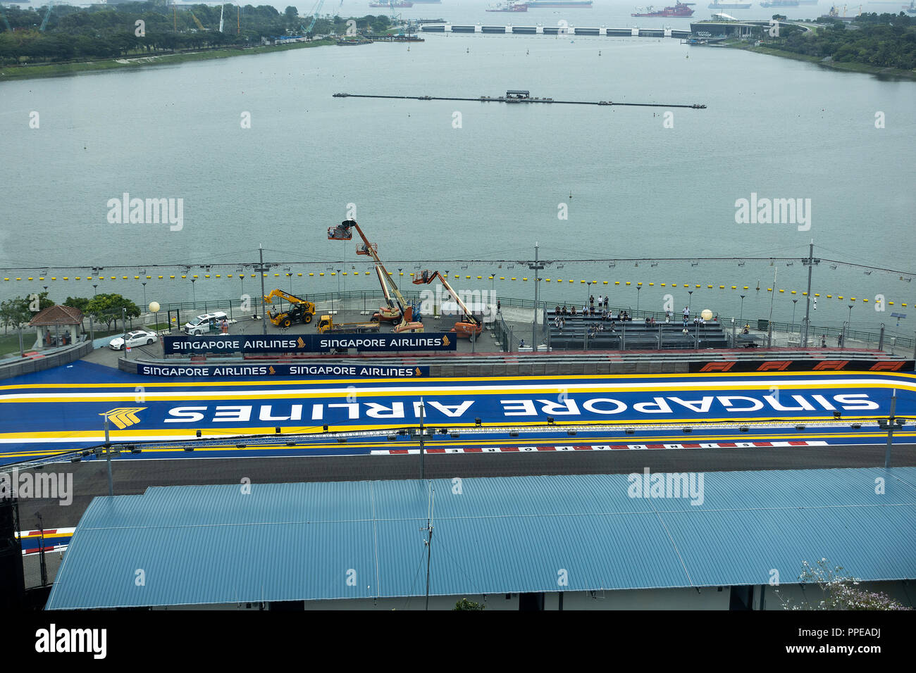 Vista aerea di una piccola tribuna coperta a fianco della Formula Uno Motor Racing via a Singapore con il Marina Bay Barrage Dam e la spedizione di Singapore Foto Stock