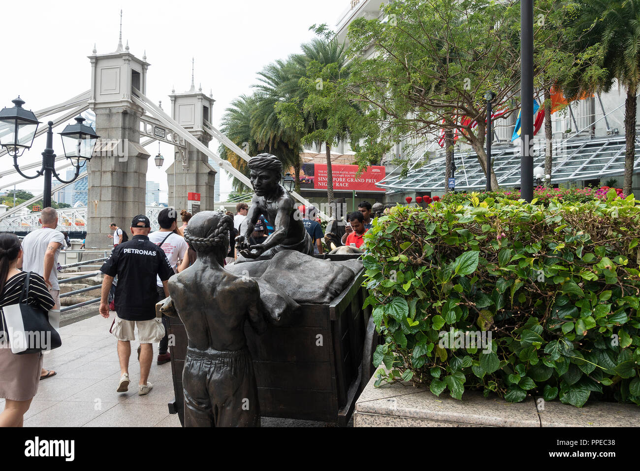 F1 sostenitori a camminare lungo il fiume mercanti scultura in bronzo vicino all'edificio Maybank e Cavanagh Bridge nel centro cittadino di Singapore Asia Foto Stock