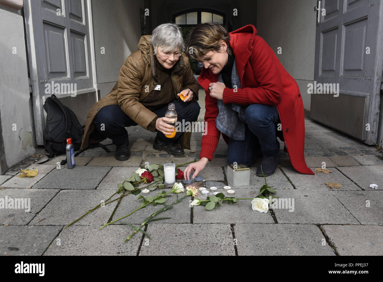 Il settantacinquesimo anniversario della deportazione di quasi 1.000 ebrei di Monaco di Baviera, membri dell'iniziativa "tolpersteine fuer Muenchen' pulire il 31 pietre di inciampo prevista nella città e decorare con fiori e candele. Barbara Stamm (a destra) e l'arte historian Susanne Partsch sono la pulizia del Stolperstein in memoria di Max Sax di fronte alla tenuta di Von-der-Tann-Strasse 7. Foto Stock