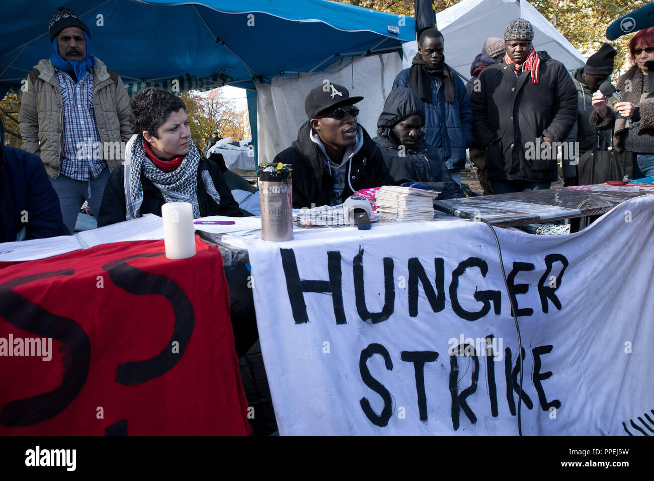 I rifugiati dimostrano per la parità e un "diritto di rimanere per tutti" con un accampamento di protesta e lo sciopero della fame in Sendlinger-Tor-Platz. La foto mostra una conferenza stampa con un sostenitore. Foto Stock