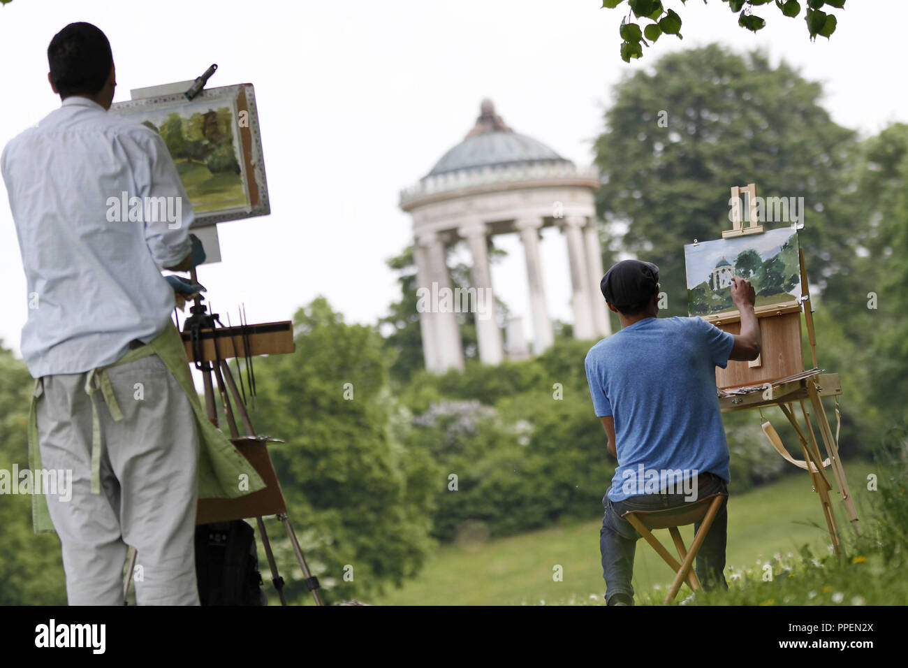 Giovani artisti con cavalletto pittura il monopteros nel Giardino Inglese di Monaco di Baviera. Foto Stock