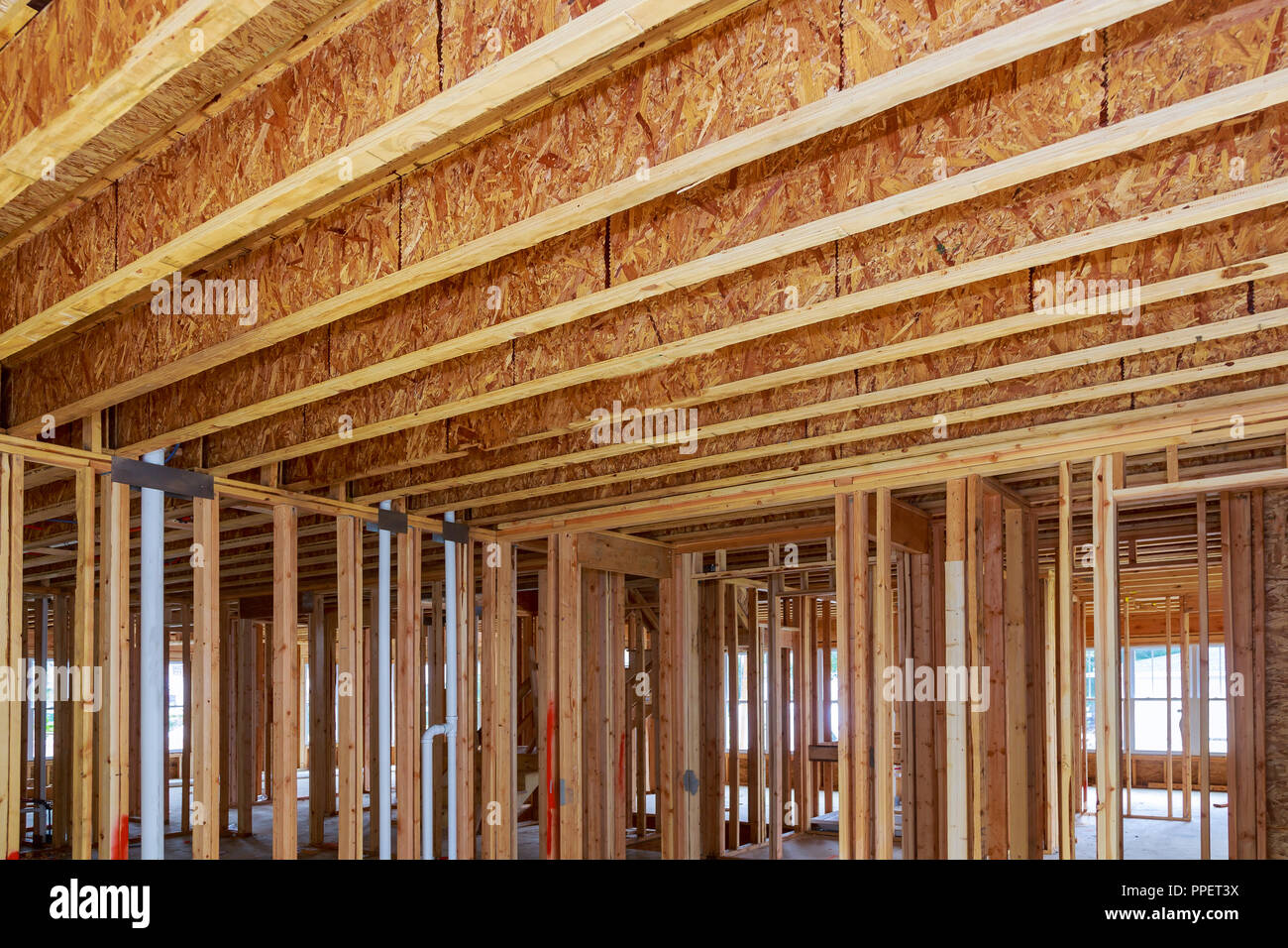 Una nuova casa in costruzione la bacchetta interna costruita e installatori all'interno di un telaio di casa. Foto Stock