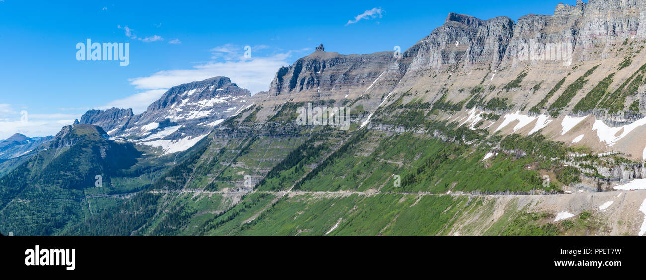 Andando al sole strada scavata nella montagna nel Parco Nazionale di Glacier, Montana Foto Stock