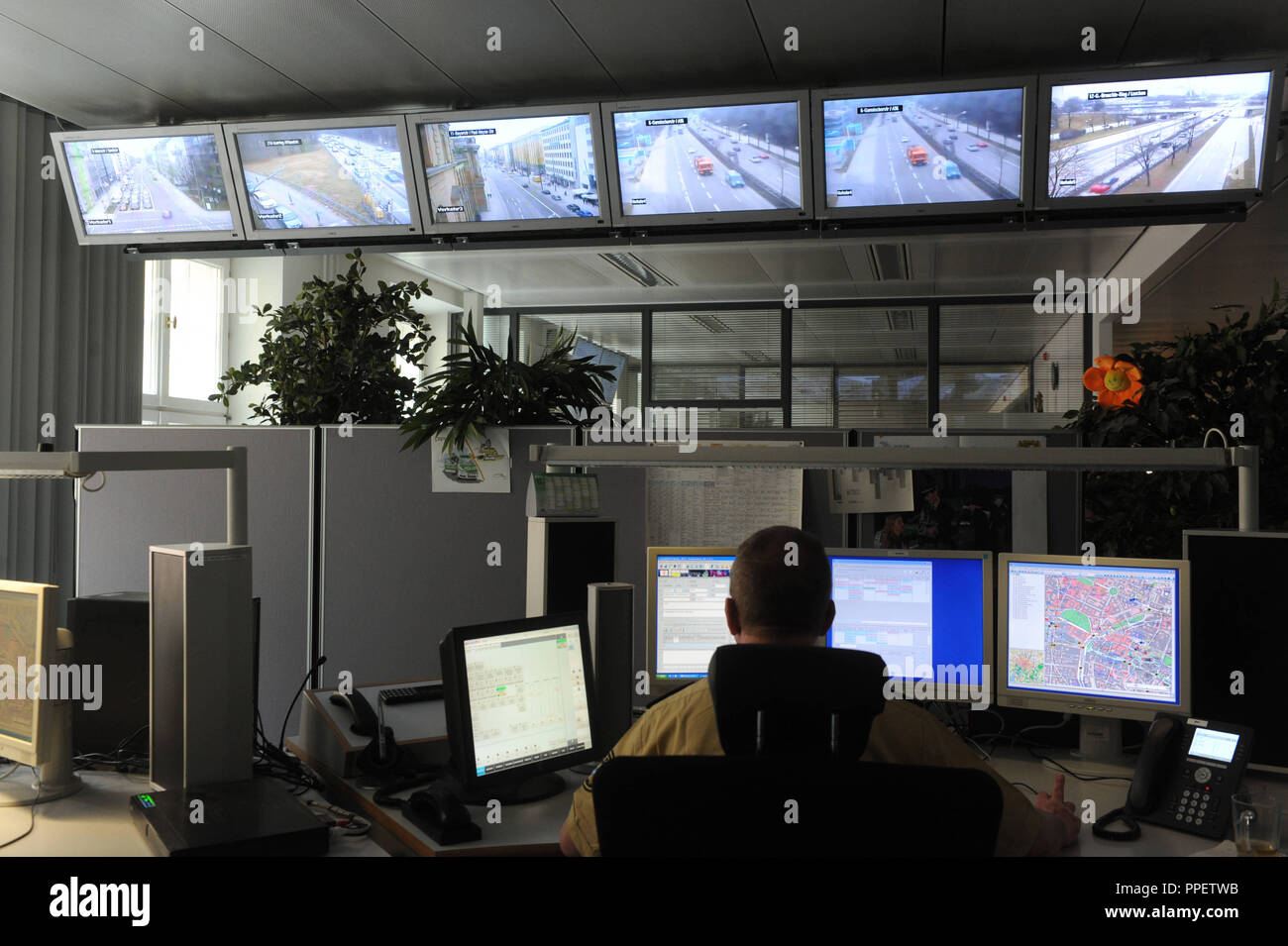 Un funzionario di polizia monitora gli eventi nelle stazioni ferroviarie e in luoghi pubblici della video camera di sorveglianza delle operazioni presso il centro di Monaco di Baviera la sede centrale di polizia. Foto Stock