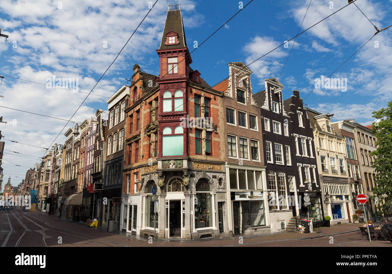 Strada tipica con vecchie case tradizionali in Amsterdam sotto il cielo blu. Foto Stock