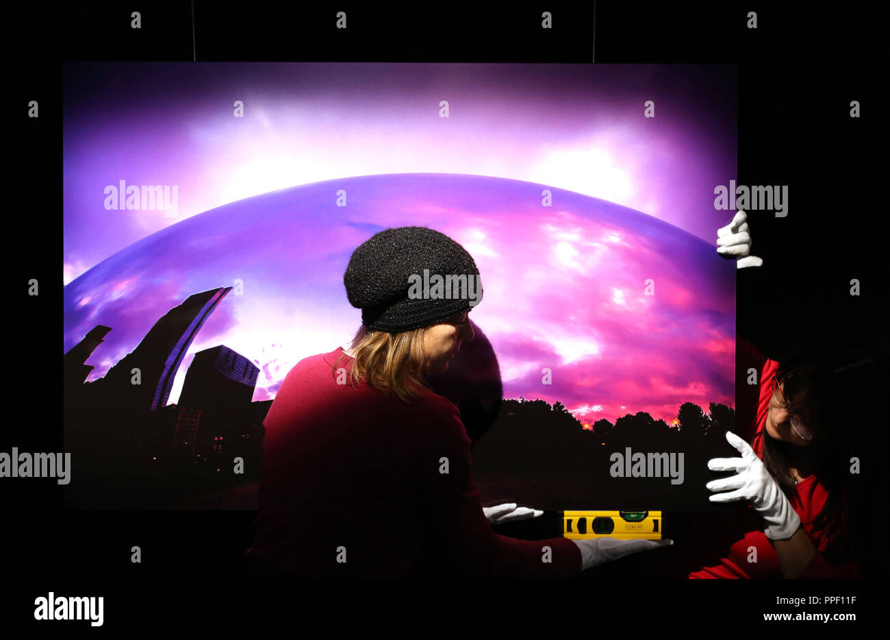 Scatti di Mike Steffl e il suo progetto 'Cloud Gate' sono attentamente maneggiata con i guanti bianchi e appeso alla parete utilizzando acqua scale durante la preparazione per la mostra "Mi piace America' . Foto Stock