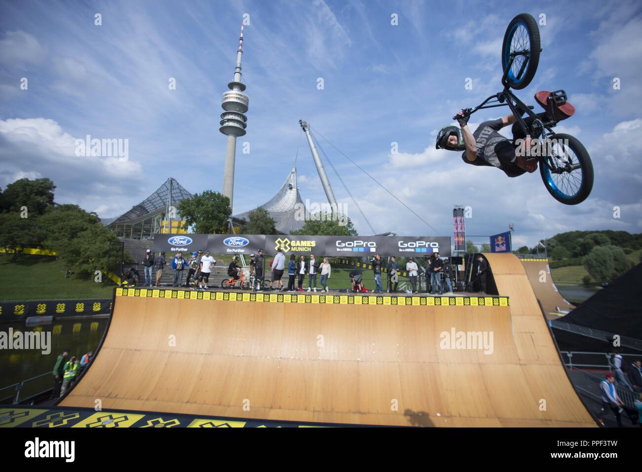 BMX trick a Tom Hawk visualizza durante il programma di apertura per la X-Games nell'Olympiapark a Monaco di Baviera. Sullo sfondo la torre olimpica. Foto Stock