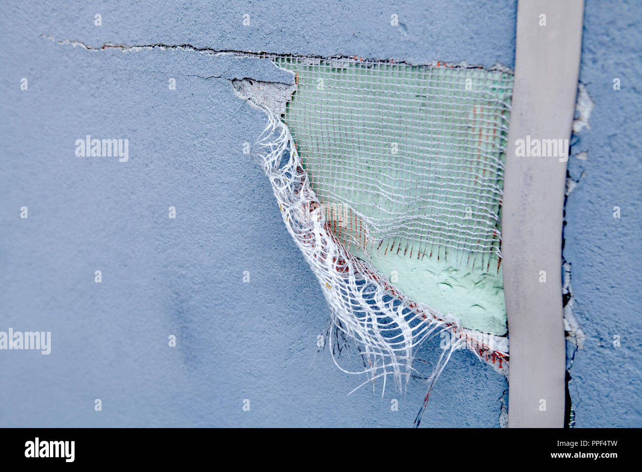 Su intonaco esterno, che è pieno di fori è possibile vedere la sottostante rete in fibra di vetro. Foto Stock