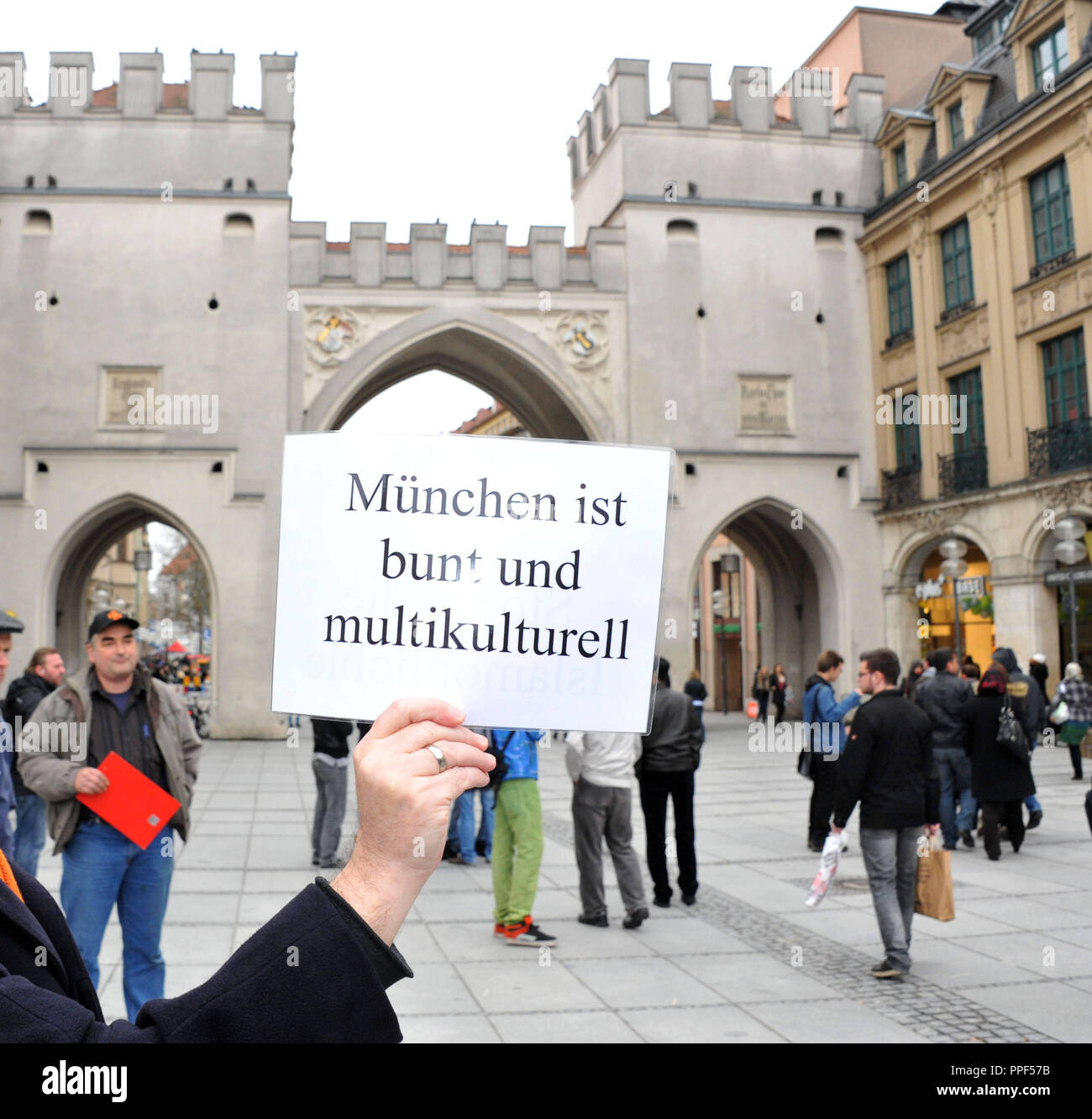 I dimostranti protestano a Stachus con 'Munich è colorato e multiculturale segni" contro la raccolta di firme del anti-islamico e partito xenofobo 'libertà' che mira una petizione pubblica contro la costruzione di una moschea nel centro della città di Monaco di Baviera. Foto Stock