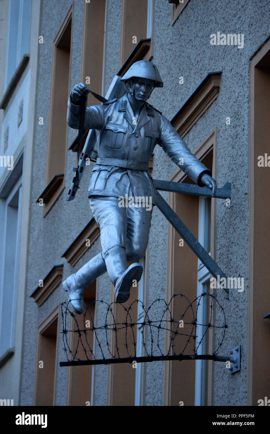 Eine Skulptur, die einem beruehmten Foto eines fluechtenden NVA-Soldaten waehrend des Mauerbaus 1963 nachempfunden ist, Brunnenstrasse, Berlin-Mitte. Foto Stock