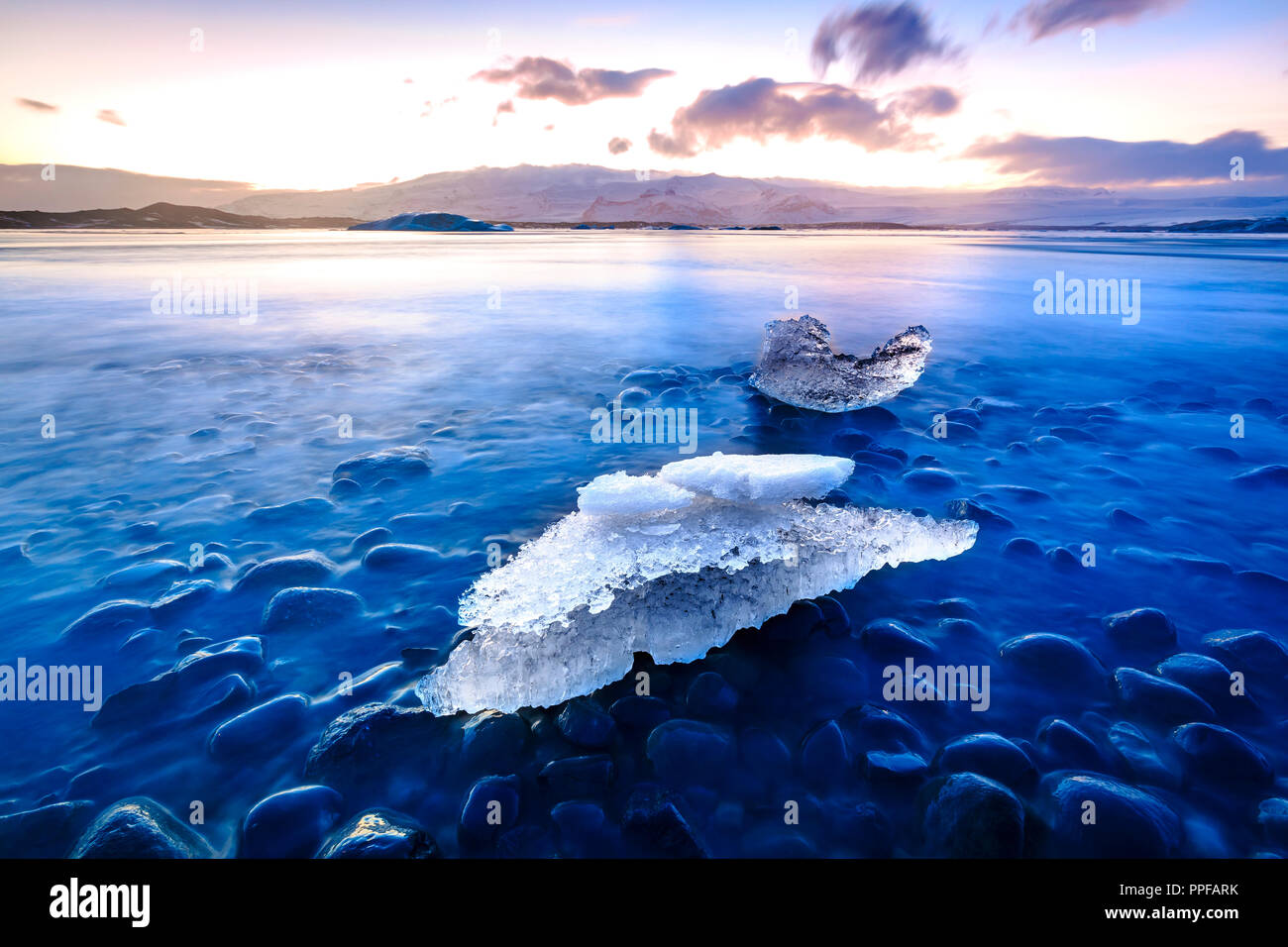 Jokulsarlon lago glaciale in Islanda durante il tramonto nella stagione invernale. Il lago è in crescita ogni anno a causa del riscaldamento globale. Un luogo popolare per i turisti Foto Stock