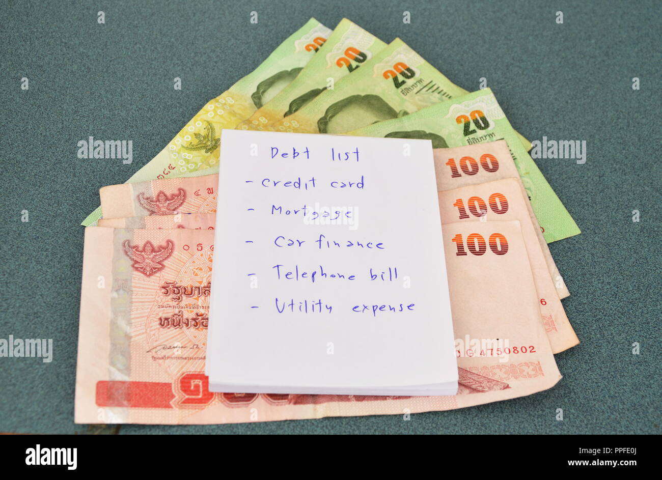 Elenco di debito e Thai denaro sul tavolo Foto Stock