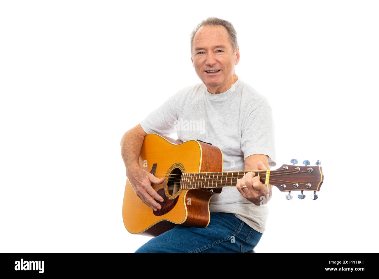 Inquadratura orizzontale di un uomo maturo felicemente giocando la sua chitarra su uno sfondo bianco. Un sacco di spazio copia. Foto Stock