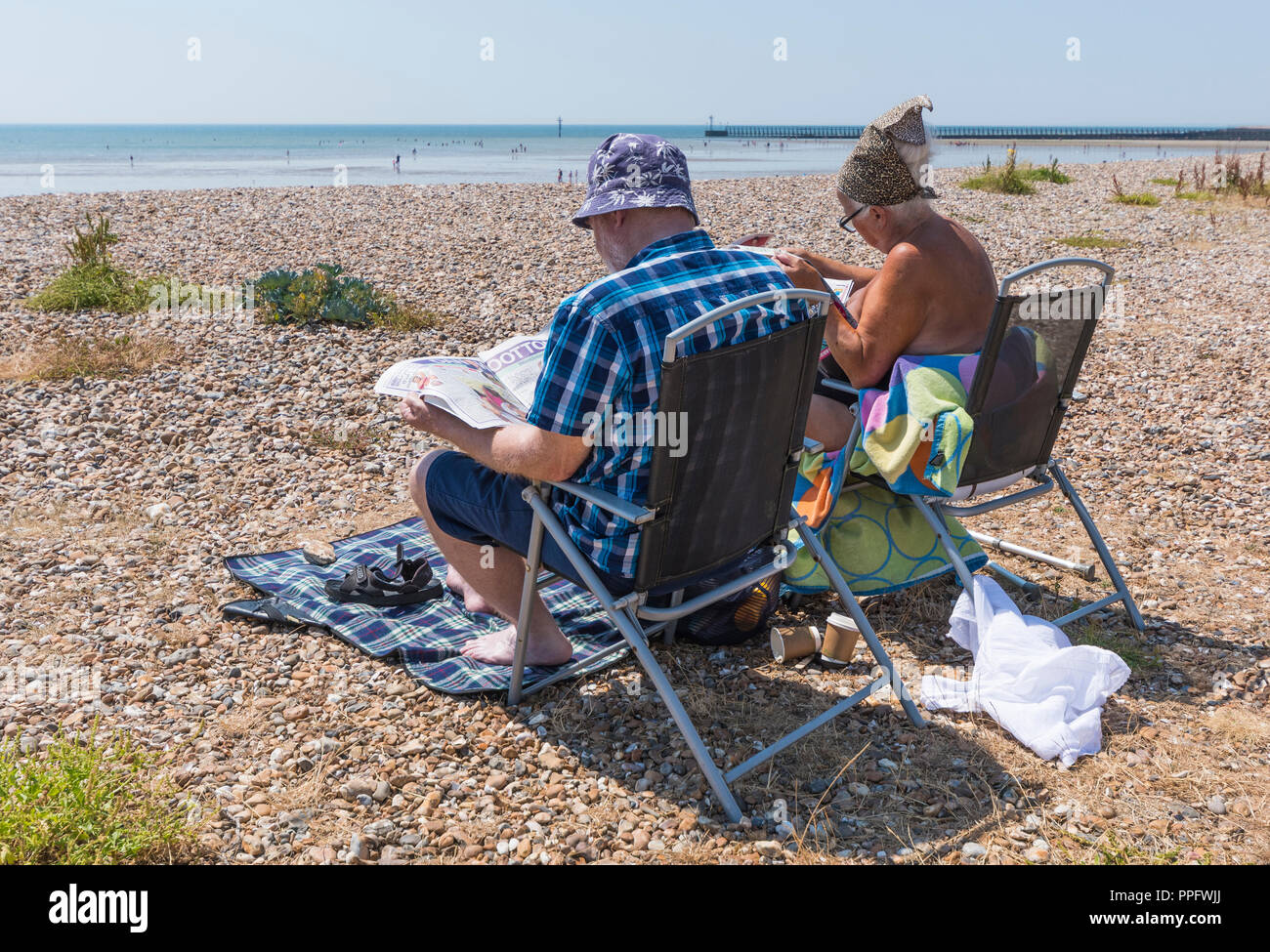 Paio di persone seduti su sedie da spiaggia in estate a Littlehampton, West Sussex, in Inghilterra, Regno Unito. Foto Stock